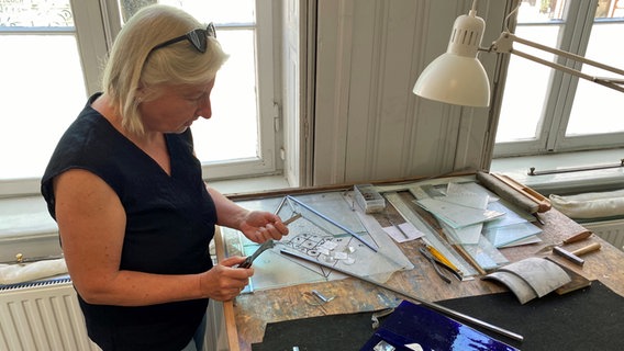 Glasrestauratorin  Eva-Maria Ziegler steht in ihrem Atelier in Lübeck und arbeitet an einem bleiverglasten Fenster. © NDR Foto: Linda Ebener