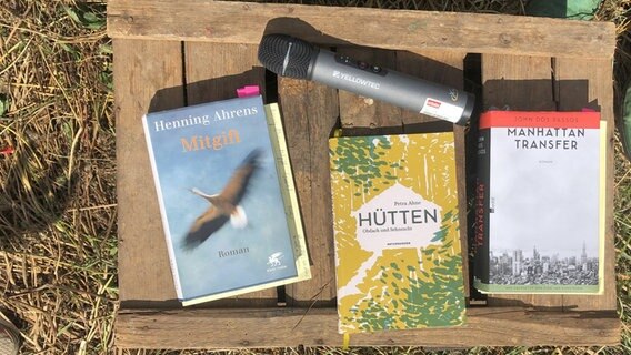 Drei Bücher und ein Mikrofon auf einem Holzbrett im Heu. © NDR Foto: Lorenz Just