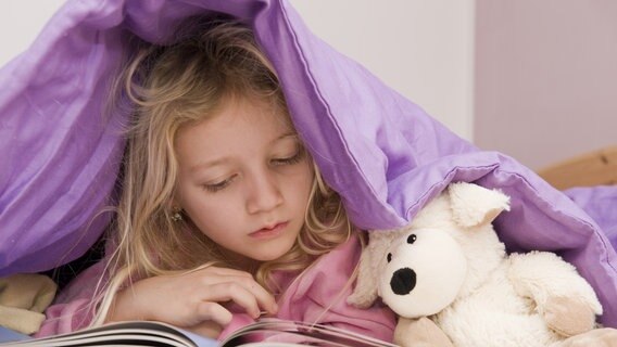 Junges Mädchen liegt im Bett und liest ein Buch © picture alliance / blickwinkel Foto: McPHOTO