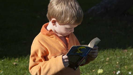 Ein Junge liest einen Comic © imago 