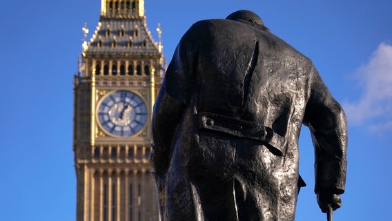 Der Big Ben am Elizabeth Tower in Westminster, London, davor die Statue des ehemaligen britischen Premiers Churchill in Rückenansicht © Foto: Alberto Pezzali/AP/dpa +++ dpa-Bildfunk +++ Foto: Foto: Alberto Pezzali