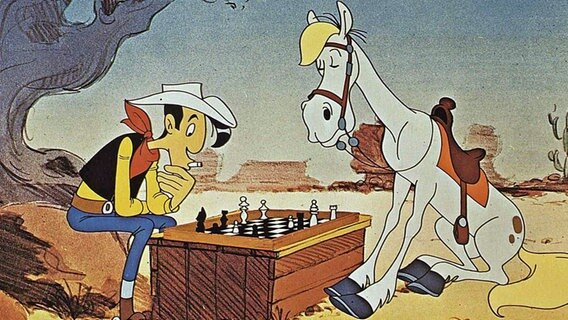 Lucky Luke und sein Pferd Jolly Jumper spielen Schach (Szene aus dem Zeichentrickfilm Daisy Town von 1971). © picture alliance / United Archives/IFTN | United Archives/IFTN 