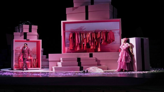Samuel Chan (Lescaut) und Agnieszka Hauzer (Manon Lescaut) auf einer rosafarbenen Bühne. Samuel Chan (Lescaut) und Agnieszka Hauzer (Manon Lescaut) auf einer rosafarbenen Bühne. © Staatsoper Kiel
