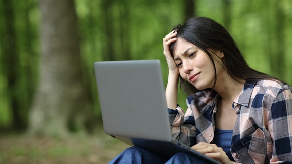 Ein Frau sitzt im Wald vor ihrem Laptop © picture alliance / PantherMedia 
