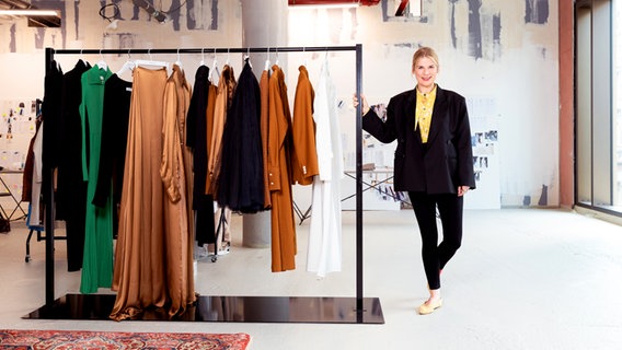 Auf dem Bild ist die Designerin Christina Fassbender zu sehen - sie steht in ihre Pop-Up-Store in der Hamburger Innenstadt neben Kleidungsstücken aus ihrer Kollektion © NDR Foto: Susanne Baade