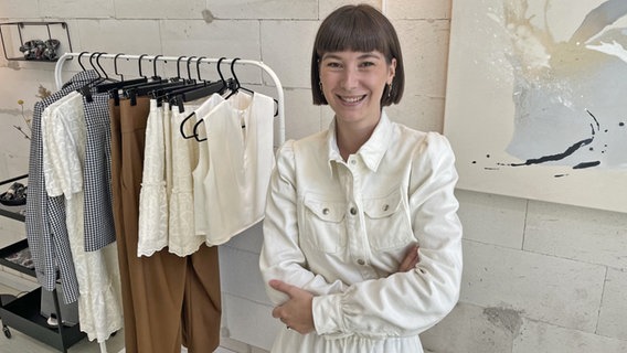 Auf dem Bild ist die Designerin Alina Klemm zu sehen. Sie trägt eine weiße Jacke mit gepufften Ärmeln aus ihrer eigenen Kollektion. © NDR Foto: Anina Pommerenke