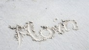 Das Wort "Moin" im Sand von Amrum geschrieben. © picture alliance / Westend61 | Westend61 / Anja Weber-Decker Foto: Anja Weber-Decker