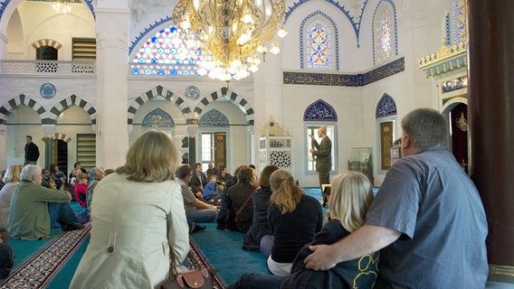 Menschen sitzen beim "Tag der Offenen Moschee" in einer Moschee © imago 