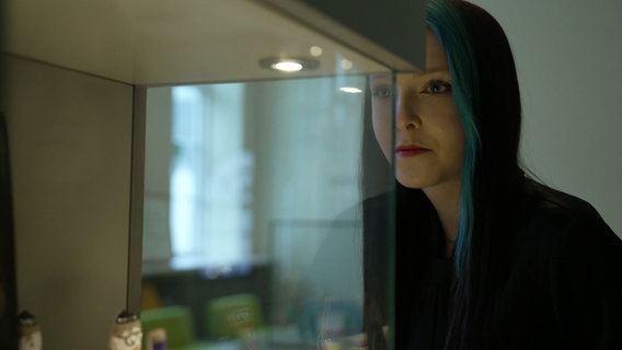 Eine Schülerin schaut in einen Glaskasten. © NDR 