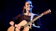 Alin Coen - eine braunhaarige Sängerin mit Gitarre in der Hand, guckt nach rechts oben. © picture alliance / Eventpress Hoensch | Eventpress Hoensch 
