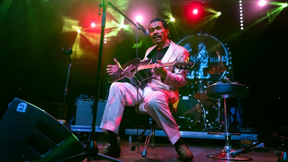 Ein älterer Mann sitzt auf einer Bühne im bunten Scheinwerferlicht und spielt Gitarre (US-Musiker und Sänger Bobby Rush) © picture alliance / Hans Lucas | Pascal Schmidt Foto: Hans Lucas / Pascal Schmidt
