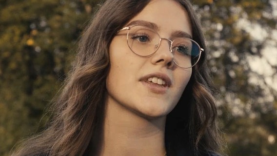 Porträt einer jungen Frau mit langen, braunen Haaren und goldener Brille © NDR 
