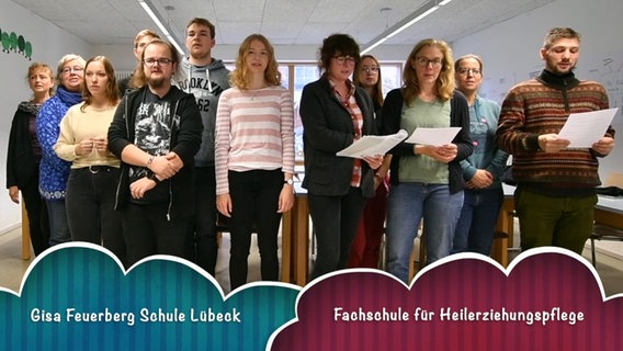 Zwölf Menschen stehen in zwei Reihen und singen, am unteren Bildrand sind die Worte "Gisa Feuerberg Schule Lübeck. Fachschule für Heilerziehungspflege" eingeblendet © NDR 