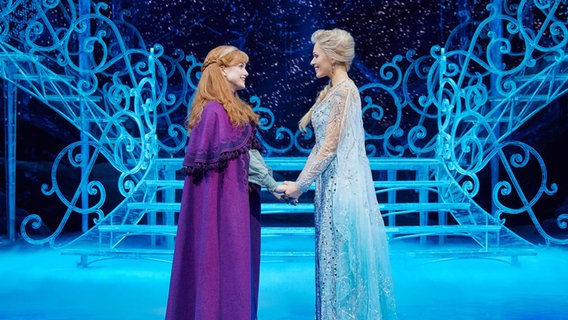 Die Darstellerinnen Sabrina Weckerlin (Eiskönigin Elsa, r.) und Celena Pieper (ihre Schwester Anna) stehen nach einer Probe für das Musical "Die Eiskönigin" auf der Bühne im Stage Theater an der Elbe. © Disney_Foto Foto: Johan Persson