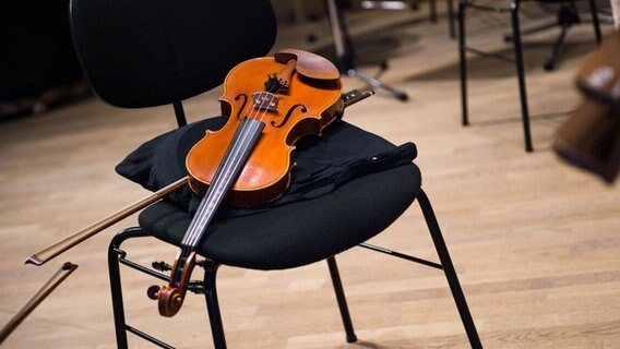 Geige liegt auf Stuhl © picture alliance / Lino Mirgeler/dpa | Lino Mirgeler Foto: Lino Mirgeler