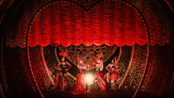 Die Lady M's inklusive Lady Chocolat (links, Oliva Grassner) im Musical "Moulin Rouge" in Köln mit rotem Frack und Zylinder © Johann Persson Foto: Johann Persson