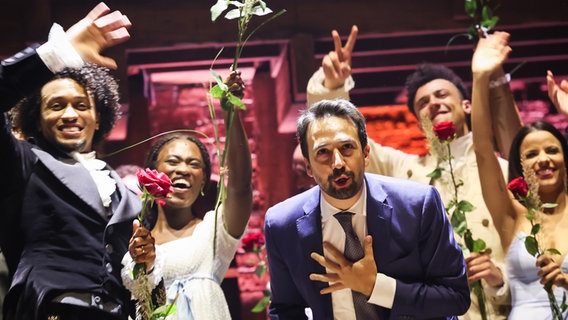 Komponist und Autor des Musicals "Hamilton" Lin-Manuel Miranda und die Musical-Hauptdarsteller Benet Monteiro (links) und Ivy Quainoo (2. von links) beim Schlussapplaus auf der Bühne © dpa Foto: Christian Charisius