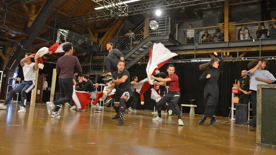 Tänzerinnen und Tänzer bei den Proben zum Musical "Hamilton" in Hamburg wirbeln mit roten Mänteln © NDR Foto: Patricia Batlle