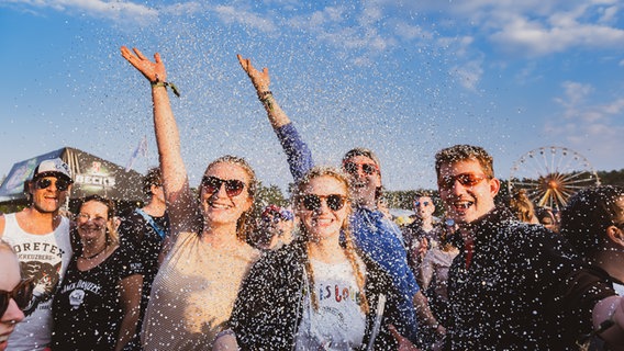 Besucher des Hurricane Festivals werfen Konfetti.  Foto: Benjamin Hüllenkremer