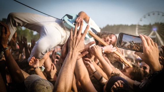 Ein Musiker beim Stage Diving durch eine Menschenmenge beim Hurricane © NDR Foto: Benjamin Hüllenkremper