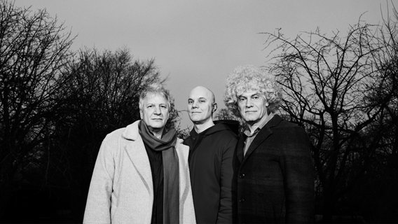 Ein Schwarz-Weiß-Foto von drei Männern im Porträt. © Alexander Popelier Foto: Alexander Popelier