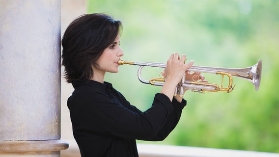Eine Frau im Profil spielt Trompete. © Carlos Pericas Foto: Carlos Pericas
