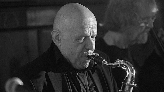 Gerd Dudek spielt Saxofon vor einem Mikrofon. © IMAGO / Foto: Rudolf Gigler