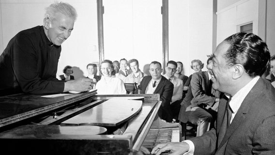 Duke Ellington und Norman O'Connor lachen herzlich an einem Flügel vor einer Klasse von Studierenden. © picture alliance / ASSOCIATED PRESS | J Walter Green Foto: J Walter Green