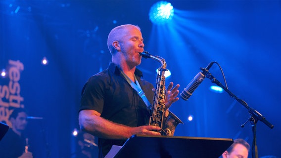 Ein Mann steht auf einer Bühne und spielt Alt-Saxofon. © Bernd Thissen Foto: Bernd Thissen