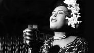 Billie Holiday auf der Bühne mit der für sie typischen weißen Gardenie im Haar. © picture alliance / Everett Collection Foto: CSU Archives / Everett Collection