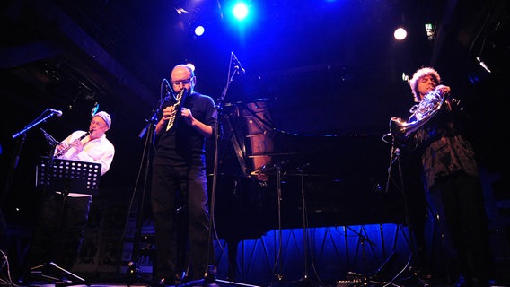 Drei Männer musizieren mit Musikinstrumenten auf einer Bühne. © Isabell Schiffler Foto: Isabell Schiffler