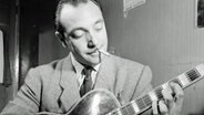 Der französische Jazzmusiker Django Reinhardt (eigentlich Jean Baptiste Reinhardt; geboren in Liverchies/Belgien am 23.1.1910 , gestorben in Fontainebleau/Frankreich am 16.5.1953) mit Gitarre im New Yorker Jazzclub "Aquarium" im November 1946. © picture-alliance / akg-images Foto: William P. Gottlieb