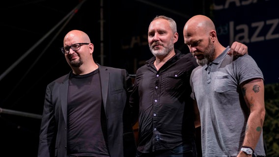 Die drei Gründungsmitglieder von The Bad Plus stehen nach einem Konzert gemeinsam auf der Bühne. © picture alliance / Pacific Press Foto: Fabrizio Sodani