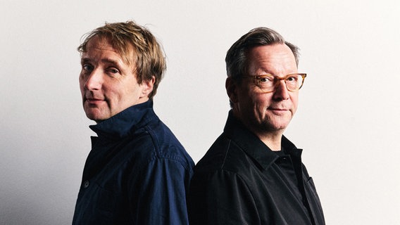 Ein Porträt zweier Männer, die Rücken an Rücken stehen. © Steven Haberland Foto: Steven Haberland