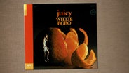 Auf dem Album Cover "Juicy" von Willie Bobo sieht man eine Frau vor einer überdimensionalen, angeschnittenen Orange tanzen. © Verve Records 