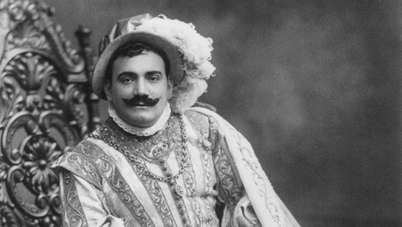 The Italian opera singer Enrico Caruso in a black and white photo with historical costumes.  © Courtesy Everett Collectionx 
