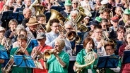 Zu Beginn des dritten Deutschen Evangelischen Posaunentags spielen rund 15.000 Blechbläserinnen und -bläser auf dem Eröffnungsgottesdienst auf der Moorweide in Hamburg. © dpa-Bildfunk Foto: Markus Scholz