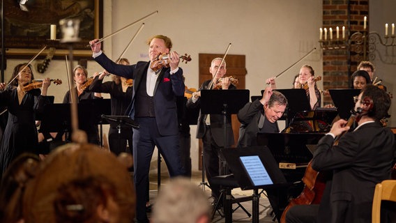Ein Geiger umgeben von Orchestermusikern © Oliver Borchert Foto: Oliver Borchert