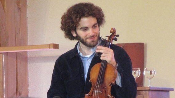 Ein Mann mit Locken hält eine Geige in der Hand. © Axel Seitz /NDR Foto: Axel Seitz