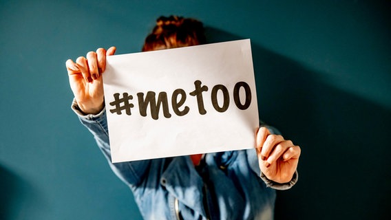 Eine Frau hält einen Zettel mit der Aufschrift "#metoo" in Höhe des Gesichtes vor sich. © picture alliance Foto: Robin Utrecht