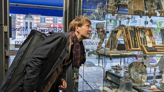 Nils Mönkemeyer betrachtet die Vitrinen der Altonaer Silberwerkstatt © NDR Foto: Christiane Irrgang