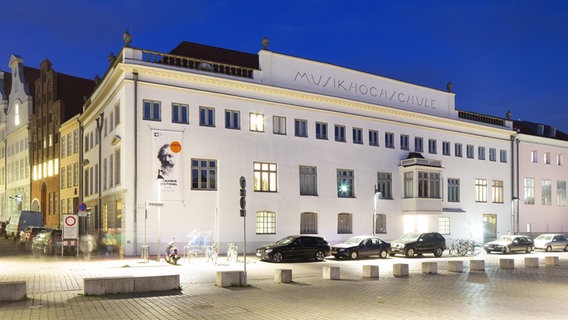 Außenansicht eines weißen Gebäudes im Abendlicht mit der Aufschrift Musikhochschule © imageBROKER Foto:  Thomas Robbin