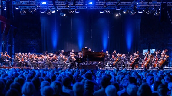 Das New York Philharmonic Orchestra spielt gemeinsam mit Jan Lisiecki am Klavier beim ersten Konzert im ehemaligen Kraftwerk Peenemünde auf der Ostseeinsel Usedom. © picture alliance/dpa Foto: Jens Büttner