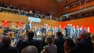 Die NDR Radiophilharmonie, Dirigent Richard Egarr und der Schleswig-Holstein Festivalchor stehen beim Abschlusskonzert des Schleswig-Holstein Musik Festivals auf der Bühne der Lübecker Musik- und Kongresshalle. © NDR Foto: Linda Ebener