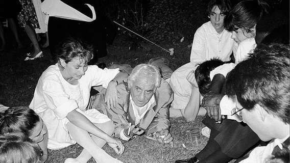 Zeltlager-Atmosphäre: Leonard Bernstein lümmelt abends zusammen mit jungen Musikern der Orchesterakademie Salzau auf dem Rasen. © Friedrun Reinhold Foto: Friedrun Reinhold
