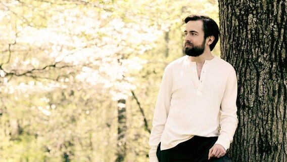 Daniil Trifonov lehnt an einem Baum © Dario Acosta/SHMF Foto: Dario Acosta