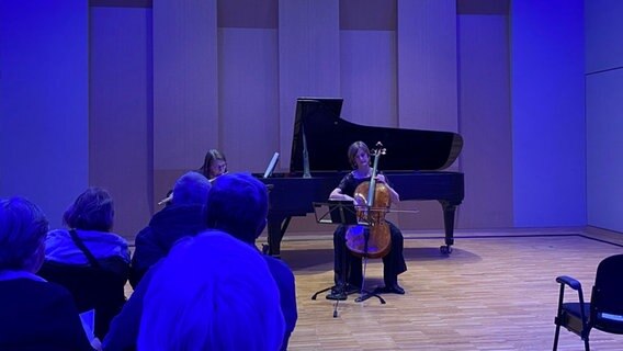 Ein Raum, der in blauem Licht erstrahlt. Drei Musikerinnen machen gemeinsam Musik. © Linda Ebener / NDR Foto: Linda Ebener / NDR