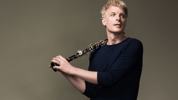 Der Klarinettist Martin Fröstim Portrait, seine Klarinette locker auf die Schulter gelehnt. © Mats Bäcker Foto: Mats Bäcker