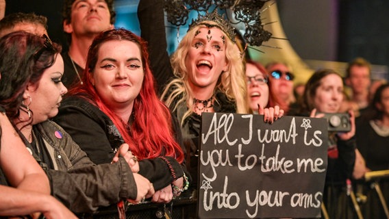 Fans mit einem Plakat vor einer Bühne beim M'era Luna 2023 © NDR Foto: Benjamin Hüllenkremper