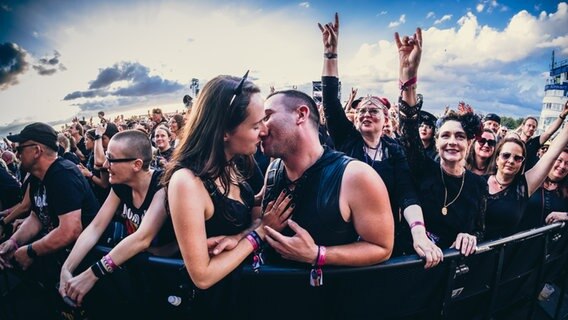 Ein sich küssendes Pärchen im Publikum beim Gothic-Musikfestival M'era Luna 2023. © NDR Foto: Benjamin Hüllenkremer